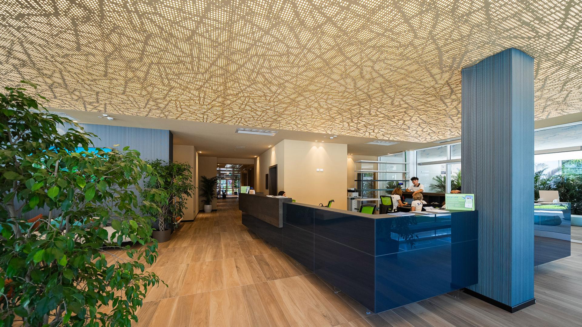 Moderne Rezeption mit dekorativer Decke und Pflanzen.